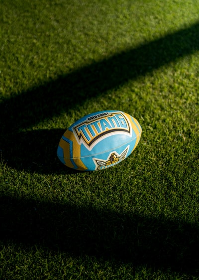blue white and orange soccer ball on green grass field